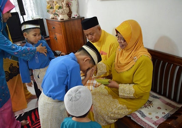 Trẻ em Hồi giáo nhận được những đồng tiền may mắn vào dịp lễ hội Hari Raya ở Malaysia
